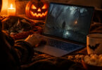 Personne utilisant un ordinateur portable pour jouer à un jeu d'horreur dans une ambiance chaleureuse d'Halloween.